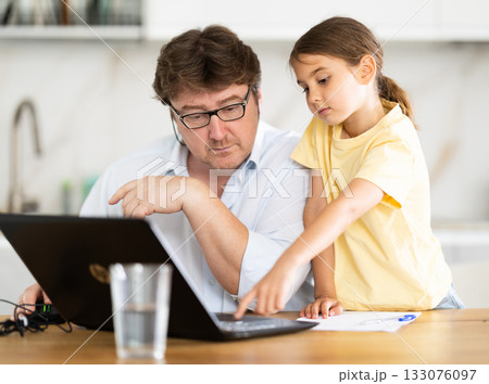 Little daughter shows her father how to use laptop Little daughter shows her father how to use laptop 133076097