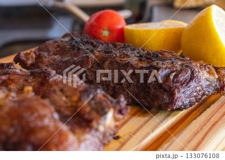 Argentinian barbecue on a rustic wooden board, with various cuts of grilled meat, representing a delicious traditional barbecue meal. Argentinian barbecue on a rustic wooden board, with various cuts of grilled meat, representing a delicious traditional barbecue meal. 133076108