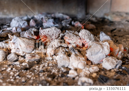 Red-hot embers and hot charcoal briquettes are ready to cook food on a barbecue .Horizontal real picture. Red-hot embers and hot charcoal briquettes are ready to cook food on a barbecue .Horizontal real picture. 133076111