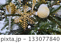Branches of Christmas tree with beautiful decorations covered with snow 133077840