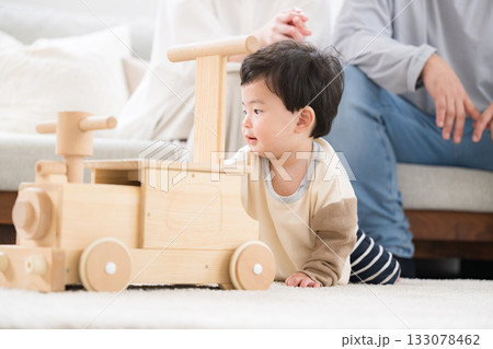 木のおもちゃで遊ぶハイハイの赤ちゃん 133078462