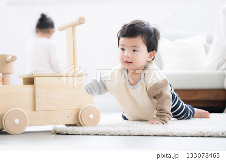 木のおもちゃで遊ぶハイハイの赤ちゃん 133078463