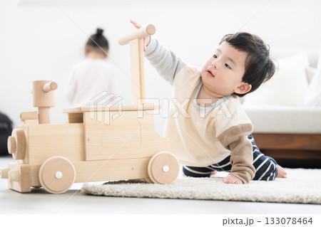 木のおもちゃで遊ぶハイハイの赤ちゃん 133078464
