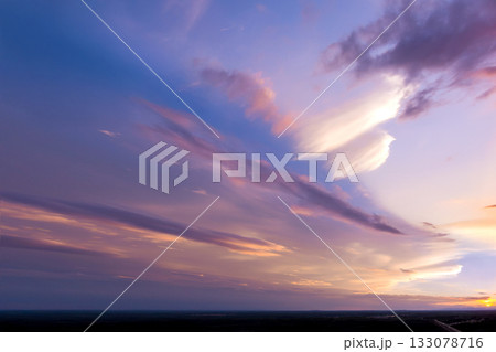 Colorful sunset sky with pink purple clouds over serene landscape during twilight hours Colorful sunset sky with pink purple clouds over serene landscape during twilight hours 133078716