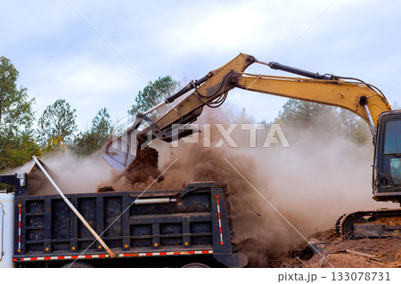 Excavator loading dirt into truck at construction site Excavator loading dirt into truck at construction site 133078731
