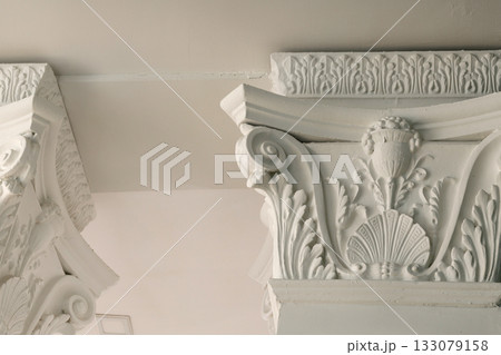 Beautiful architectural moldings on the columns under the ceiling. White 133079158