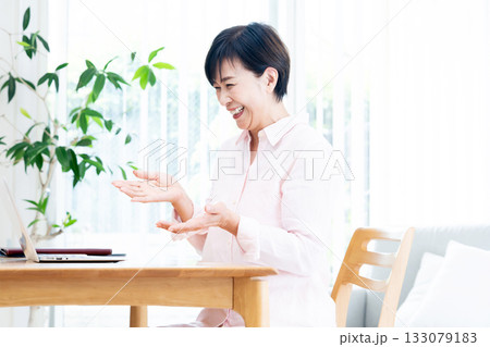 リビングでテレワークするミドルの女性 リビングでテレワークするミドルの女性 133079183