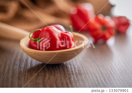 Red chili pepper habanero on wooden spoon on wooden table. 133079901