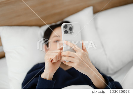 ベッドでスマホを見る女性 133080098