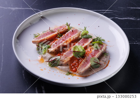 Seared Tuna Steak Slices on Creamy Sauce with Fresh Greens 133080253