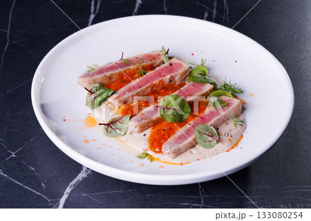 Seared Tuna Steak Slices on Creamy Sauce with Fresh Greens 133080254