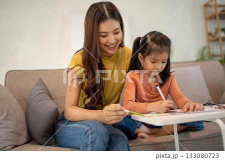 Lovely mom and little young daughter spending time together in their living room. 133080723