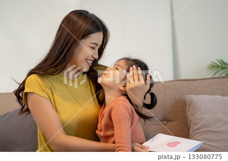 Lovely mom and little young daughter spending time together in their living room. 133080775