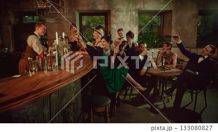 Elegant friends toasting in retro bar interior with lively vintage atmosphere Elegant friends toasting in retro bar interior with lively vintage atmosphere 133080827