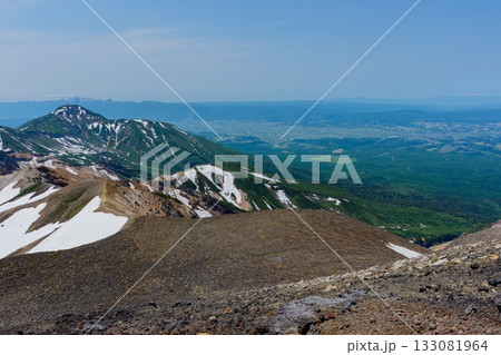 北海道・上ホロカメットク山から十勝岳への縦走路より望む残雪の富良野岳　百名山登山 133081964