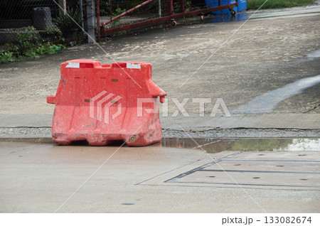Red plastic barriers set up along the roadside Red plastic barriers set up along the roadside 133082674