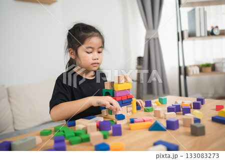 Young Child Engaged in Colorful Building Block Play, Developing Creativity and Fine Motor Skills in a Bright Indoor Environment Young Child Engaged in Colorful Building Block Play, Developing Creativity and Fine Motor Skills in a Bright Indoor Environment 133083273