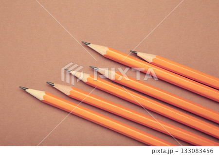 Graphite pencil with eraser on brown background. School stationery. Vertical photo Graphite pencil with eraser on brown background. School stationery. Vertical photo 133083456
