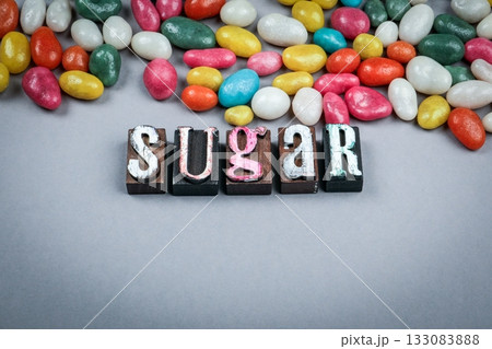 Word sugar made from vintage wooden letterpress blocks with colorful candies on gray background Word sugar made from vintage wooden letterpress blocks with colorful candies on gray background 133083888