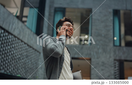 selfassured male business owner participates in phone discussion in contemporary lobby area selfassured male business owner participates in phone discussion in contemporary lobby area 133085000