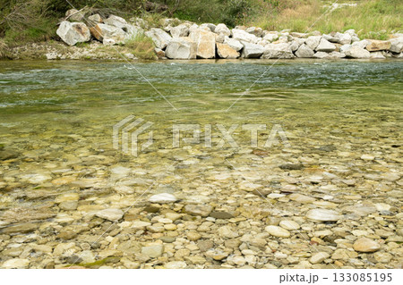 Close-up of a turbulent mountain river with a rocky bottom and shore Close-up of a turbulent mountain river with a rocky bottom and shore 133085195