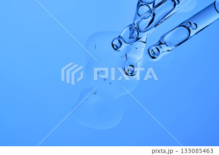 The texture of the facial serum on a blue background with pipettes. The texture of the facial serum on a blue background with pipettes. 133085463
