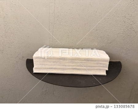 Stack of paper napkins on metal shelf. Cleanliness, organization, and minimalism in functional interior design. Stack of paper napkins on metal shelf. Cleanliness, organization, and minimalism in functional interior design. 133085678