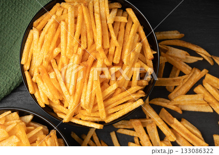 Fried chips sticks, finger potato chips, golden shoestring fries pile, French fries Fried chips sticks, finger potato chips, golden shoestring fries pile, French fries 133086322