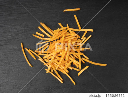 Fried chips sticks, finger potato chips, golden shoestring fries pile, French fries 133086331