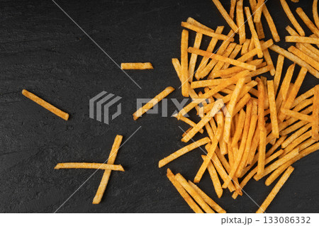 Fried chips sticks, finger potato chips, golden shoestring fries pile, French fries 133086332