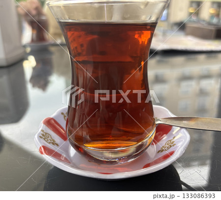 Turkish Tea on a Street Cafe Table, Traditional Arabic Cup in Restaurant, Black Tea Drinking Turkish Tea on a Street Cafe Table, Traditional Arabic Cup in Restaurant, Black Tea Drinking 133086393