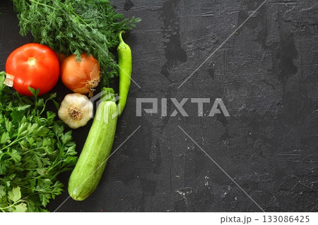 Food cooking background on black stone table. Fresh vegetables, herbs. Ingredients for cooking. Top view with copy space. 133086425