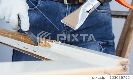 Carpenter at work, restoring an old wooden window. Carpentry. Carpenter at work, restoring an old wooden window. Carpentry. 133086796