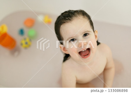 Bath time with laughing toddler in family bathroom 133086898