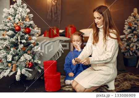 People reparing for Christmas. Kid with bengal lights. Family is resting in a festive room. Child in a blue sweater. 133086909