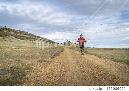 senior man is Nordic walking in foothills of Rocky MOuntains in Colorado - Prairie Ridge Natural Area senior man is Nordic walking in foothills of Rocky MOuntains in Colorado - Prairie Ridge Natural Area 133086922