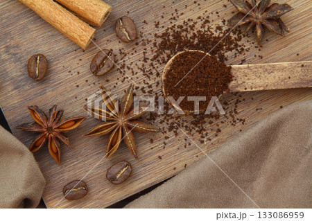 Coffee beans, cinnamon sticks, anise and wooden spoon close-up Coffee beans, cinnamon sticks, anise and wooden spoon close-up 133086959