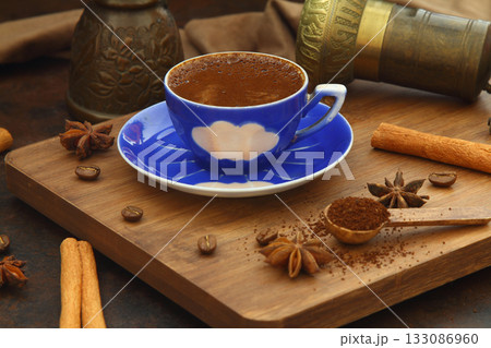 Coffee beans and ground coffee in wooden spoons on brown background. Coffee beans and ground coffee in wooden spoons on brown background. 133086960