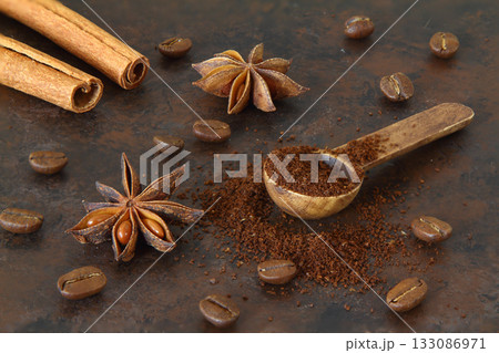 Coffee beans, cinnamon sticks, anise and wooden spoon close-up Coffee beans, cinnamon sticks, anise and wooden spoon close-up 133086971