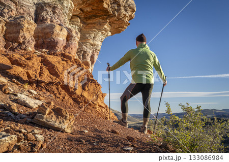 senior hike hiker in his 70s with trekking poles enjoying scenic views in Red Mountain Open Space in northern Colorado 133086984