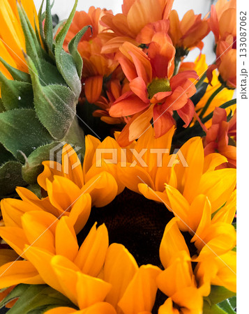 Beautiful floral bouquet with vibrant sunflowers mixed with orange and yellow flowers. Sunflowers with bold petals, smaller blooms add pop of color. Lively display perfect for decor or celebrations Beautiful floral bouquet with vibrant sunflowers mixed with orange and yellow flowers. Sunflowers with bold petals, smaller blooms add pop of color. Lively display perfect for decor or celebrations 133087062