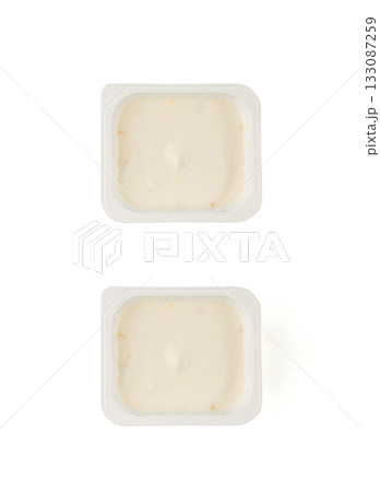 Yogurt cup isolated, yoghurt with orange fruits pieces in plastic pot, milk pudding container 133087259