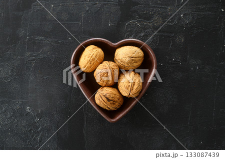 Inshell walnuts in a heart-shaped plate. Heart Nuts, Heart Health Products, Structured Walnuts Healthy food protein 133087439