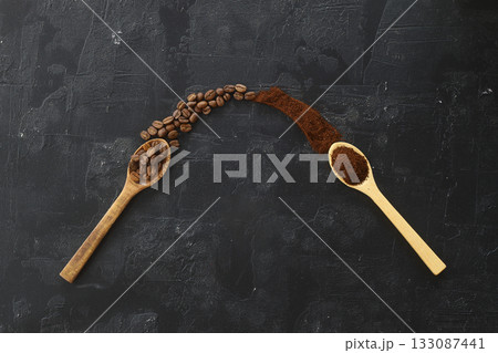 two spoons with coffee on a black background. One spoon with coffee beans. Second spoon with ground coffee. two spoons with coffee on a black background. One spoon with coffee beans. Second spoon with ground coffee. 133087441
