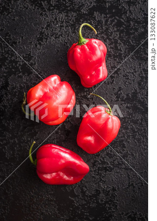 Red chili pepper habanero on black table. Top view. Red chili pepper habanero on black table. Top view. 133087622