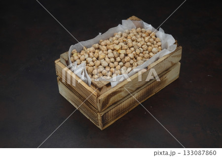 chickpeas in a small wooden crate, isolated on black background. With Wooden Spoon. 133087860