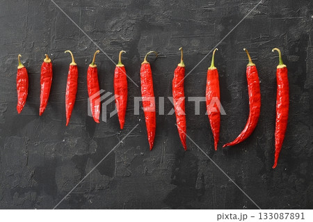 fresh chili peppers on black background,ripe red chili peppers. Top view. Mexican cuisine. fresh chili peppers on black background,ripe red chili peppers. Top view. Mexican cuisine. 133087891