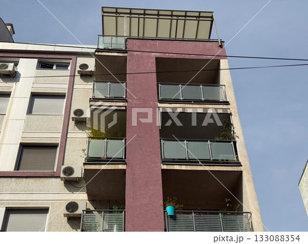 Modern apartment building with balconies and glass railings. Urban architecture, residential development, and city lifestyle in Belgrade. 133088354