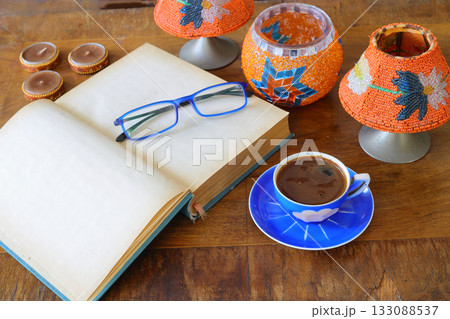 Morning coffee. Cozy composition: a cup of coffee on an open book. Still life concept. Copy space 133088537
