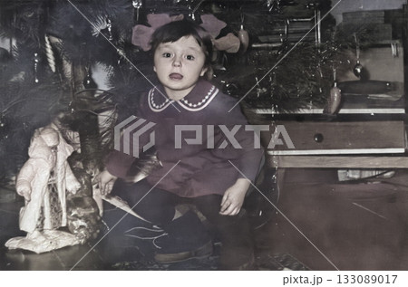Vintage portrait of a cute little girl by the Christmas tree. Retro photo from 1972. Vintage portrait of a cute little girl by the Christmas tree. Retro photo from 1972. 133089017